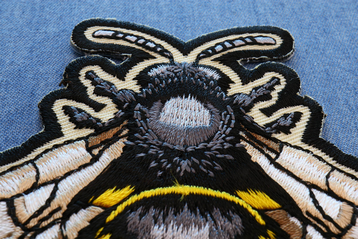 Macro view of the Bee patch head, wings and thread detail