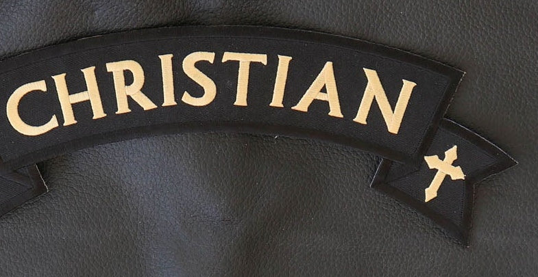 Close-up of Christian rocker patch lettering, cross and embroidered edge