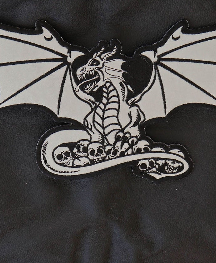 Close-up of dragon head, skulls and reflective embroidered details
