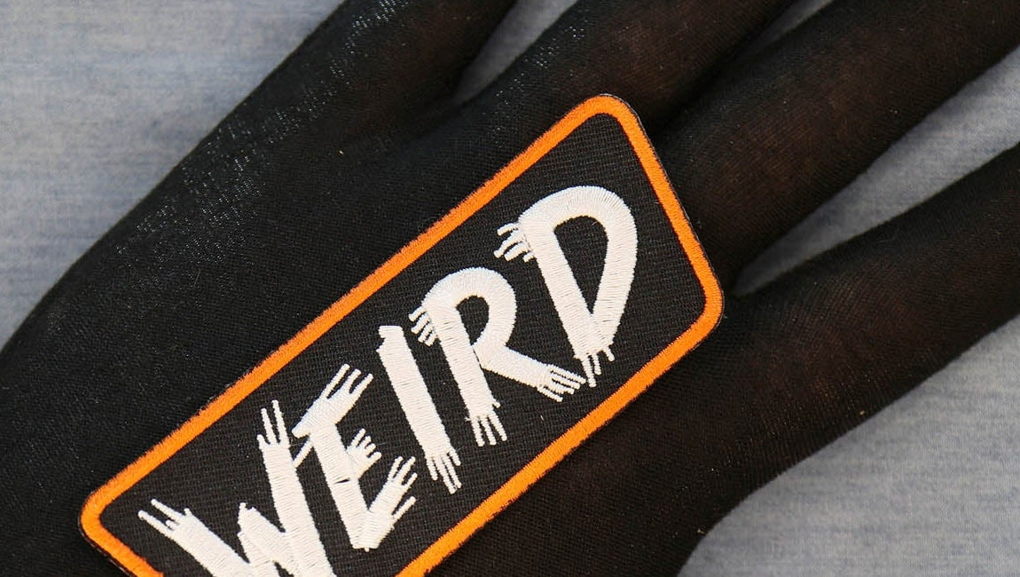 Close-up of WEIRD lettering and orange embroidered border