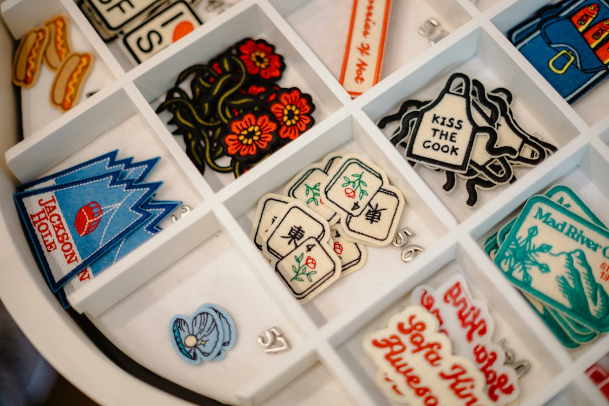 Colorful embroidered patch shapes in a display tray